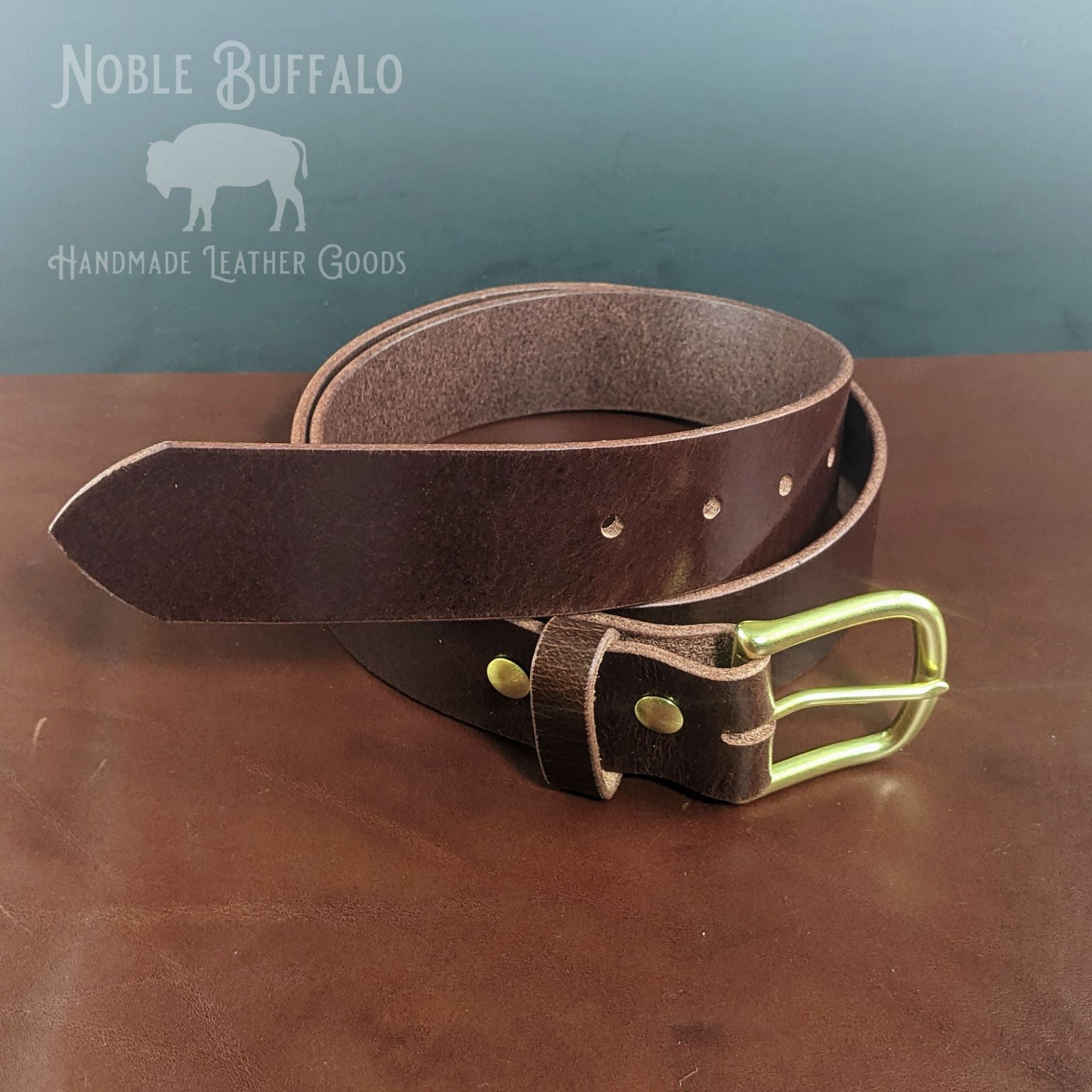 Handmade mahogany buffalo leather belt with solid brass buckle and riveted keeper, crafted by Noble Buffalo in St. Louis, Missouri