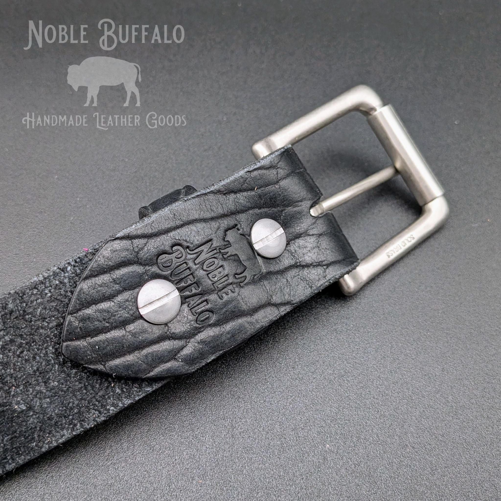 Close-up of black American Bison handmade leather belt with solid metal buckle and hardware, American made full grain leather belt
