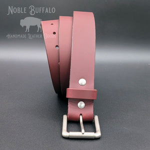 Burgundy latigo leather belt coiled upright with matte nickel roller buckle