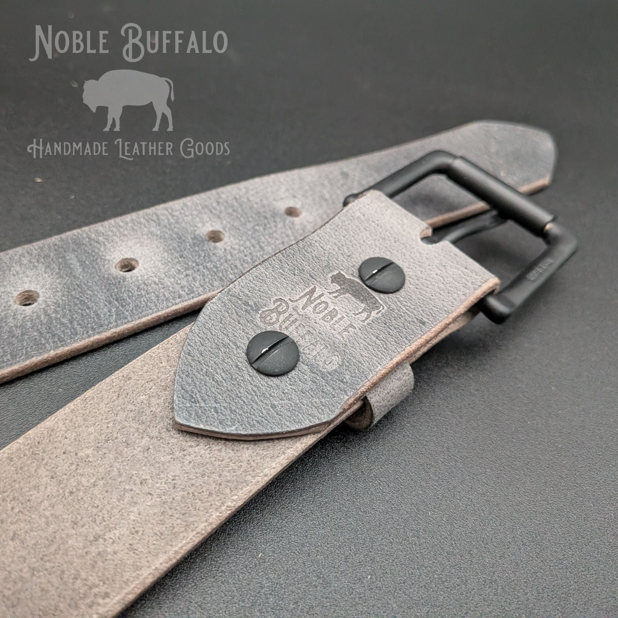 Close-up of ashy gray Crazy Horse water buffalo handmade leather belt with matte black buckle and hardware, rugged full grain leather belt made in USA
