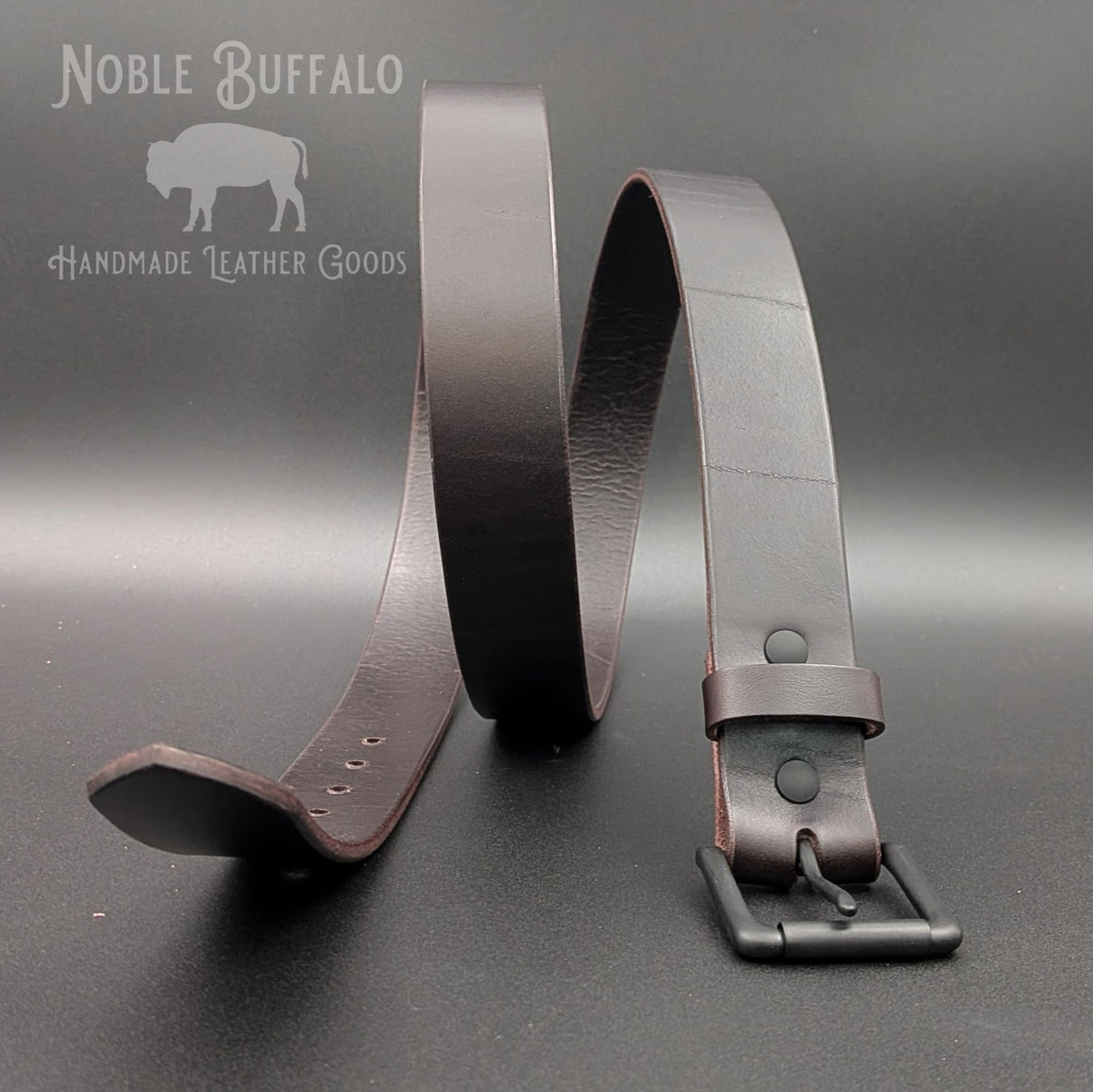 Full-length Roasted Arabica brown leather belt arranged upright to show its smooth finish, natural grain, and matte black hardware.